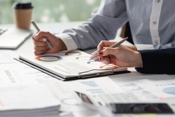 Team members reviewing financial data and strategies, using charts and documents for effective planning.