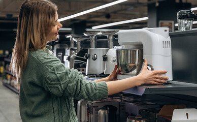 Kitchen stuff. Woman is in the hardware store, shopping conception