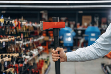 An axe in hand. Detailed close up view of man's hand in the hardware store