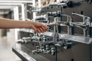 Bathroom tap. Close up view of woman that is in the hardware store