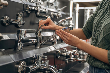 Toilet tap. Close up view of woman that is in the hardware store