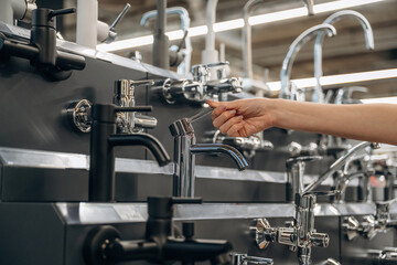 Tap for kitchen. Close up view of woman that is in the hardware store