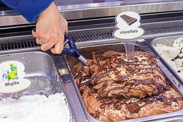 putting a chocolate ice cream scoop into a waffle cone