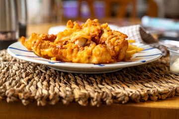 Fish and chips on bamboo pad on table