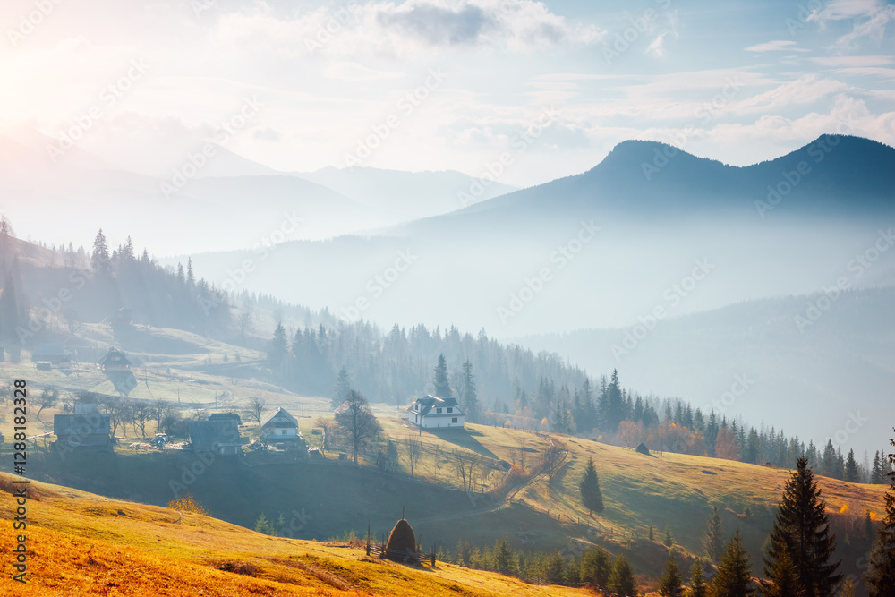 Poster majestic rustic scene with rolling hills and distant huts illuminated by sunlight. carpathian mounta