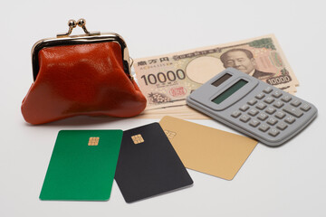 一万円札とがま口と財布とクレジットカード