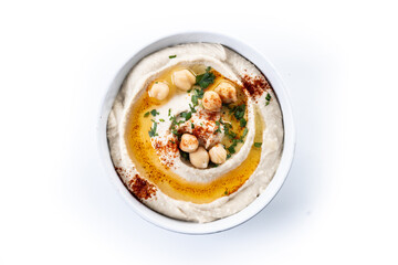 Chickpea hummus with olive oil, parsley and paprika in bowl isolated on white background