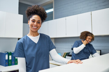 Smiling Female Healthcare Professional in Uniform Working at a Medical Reception Desk