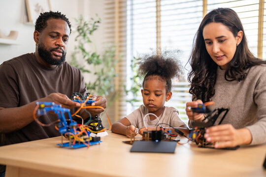 African love family, father mother and daughter learning STEM education, science experiment, robotics toy, technology and innovation interactive learning, creativity and development at home