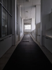 Long Dimly Lit Corridor with Natural Light Streaming Through Windows