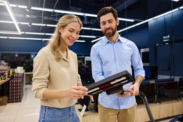 A Couple Engaging in the Process of Shopping for Modern Appliances in a Contemporary Store