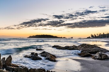 Coastal landscape at sunset with rocky shoreline.