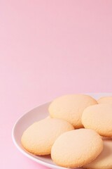 Obraz premium Soft, round cookies arranged on white plate against pastel pink