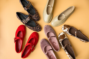 Flat lay of trendy ballet flats arranged in a circular pattern on a pastel background. The collection includes suede, leather, velour and patterned designs in red, beige, pink, leopard, cow print.