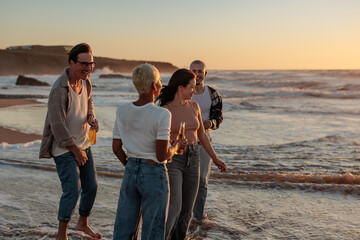 Friends enjoying drinks at sunset on beach