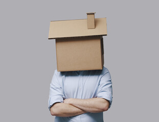 Pensive man with head inside a cardboard house