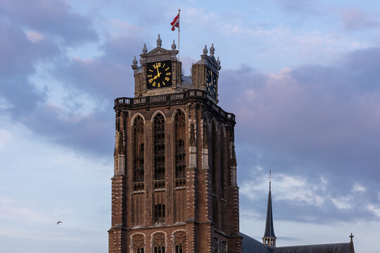 A majestic Gothic church under a dramatic cloudy sky. The intricate brickwork, towering windows, and clock tower reflect its historic architecture and timeless grandeur. - Powered by Adobe