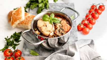 Traditional French bouillabaisse soup with fish fillets and seafood in tomato sauce.