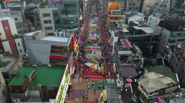 Pull-back aerial footage of the people walking on the Hongdae Street in Seoul, South Korea