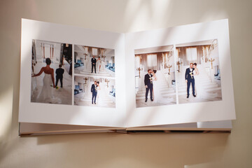  an open photo book with wedding photos on a white table