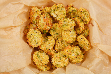 A top-down shot of baked soy patties arranged in a paper-lined container, showcasing their golden-brown color and rustic texture