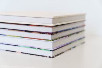 Folded photo books with white leather and multi-colored photo covers.