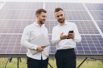 Two solar panel farm owners or engineers discussing business or technical status of solar panels...