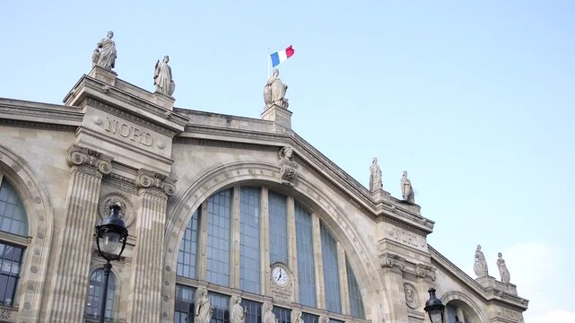 French flag waves above Gare du Nord train station on a summers day