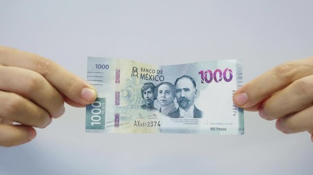 Hands showing a one thousand mexican pesos banknote