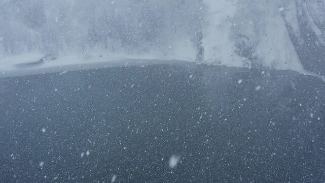 スーパースロー映像：ドローンで空撮した、大雪の日の川の上の風景
