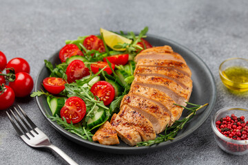 grilled  chicken breast with vegetable salad on grey plate, healthy food and diet concept, top view