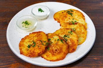 Delicious potato pancakes served with creamy sauce and herbs