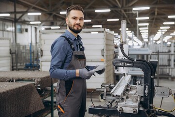 Factory male worker controlling aluminum window and door production process