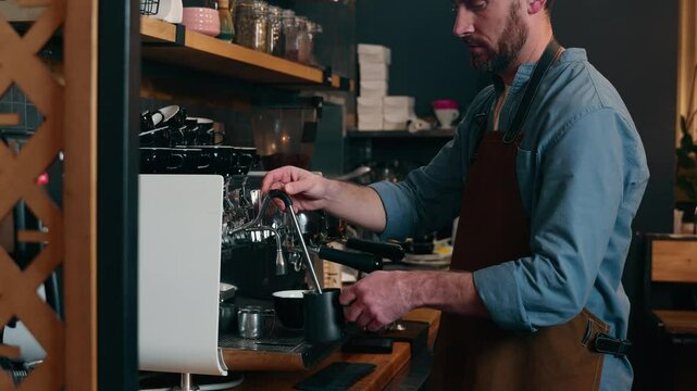 Caucasian waiter staff man guy employee making drink latte in cafe worker adding milk foam in cappuccino cafeteria barista using coffee machine catering small business male in apron serving customer