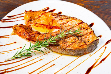 Grilled salmon steak garnished with rosemary and lemon slice