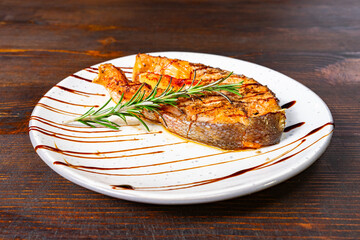 Grilled fish served with herbs on a white plate