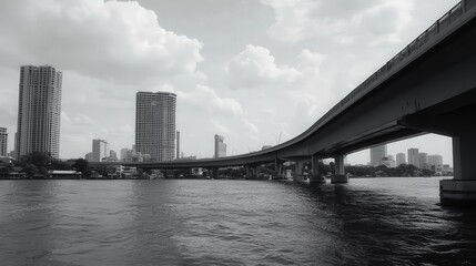 Fototapeta premium the expressway bridge spanning the Chao Phraya River, its curved silhouette cutting sharply across the expansive water