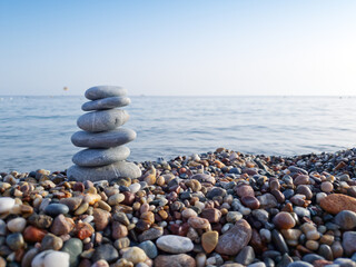 Spa stones balance on the sand of the beach.
