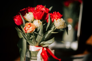 Bright tulip vase near mirror reflects spring sunshine in a cozy indoor setting