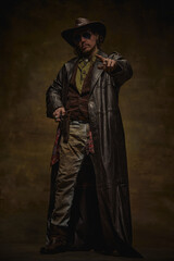 Man, sheriff pointing forward, wearing cowboy hat, long leather coat, brown vest over green shirt,...