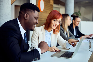 Colleagues Collaborating on Laptop During a Business Meeting in a Bright Office
