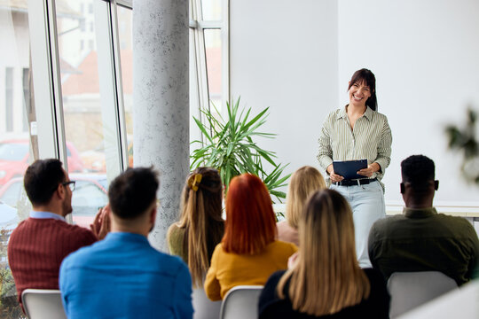 Woman Giving a Presentation to an Engaged Group in a Modern Setting