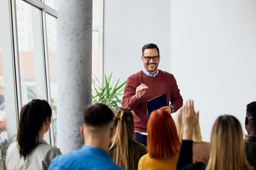 Confident Male Speaker Engaging with Audience During an Informative Presentation in a Bright Room