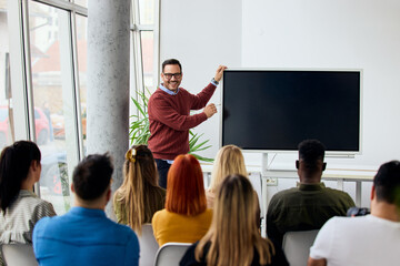Smiling Presenter Conducting Interactive Workshop in Modern Conference Room with Audience