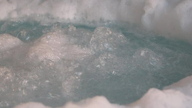 Close-up of bubbling water in a jacuzzi. The scene highlights relaxation, luxury, and a spa-like ambiance.