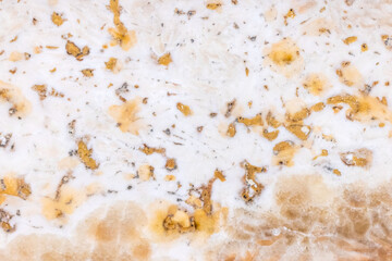 Textured stone surface exhibiting an intricate yellow white pattern
