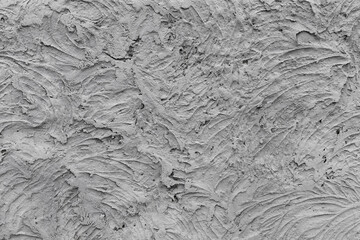 Grungy gray concrete wall with chaotic relief texture, front view