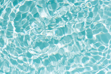 Blue water with ripples on the surface. Defocus blurred transparent blue colored clear calm water surface texture with splashes and bubbles. Water waves with shining pattern texture background.