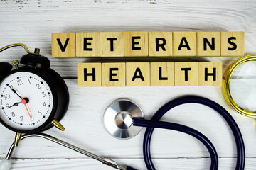 Veterans Health with wooden blocks alphabet letters and stethoscope on wooden background, Healthy and wellness concept
