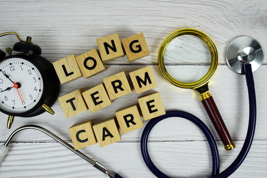 Long term care with wooden blocks alphabet letters and stethoscope on wooden background, Healthy and wellness concept